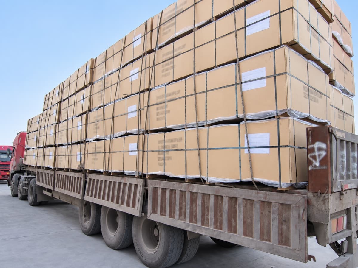 Truck loaded with protected MDF bundles for delivery to the loading port