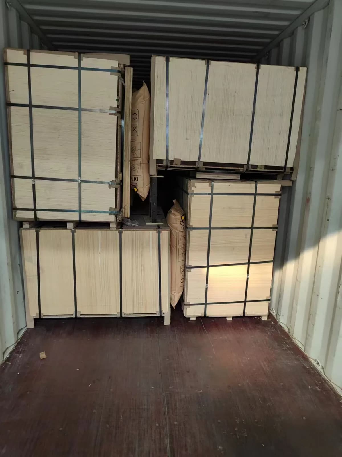 Strapped MDF bundles positioned inside a shipping container