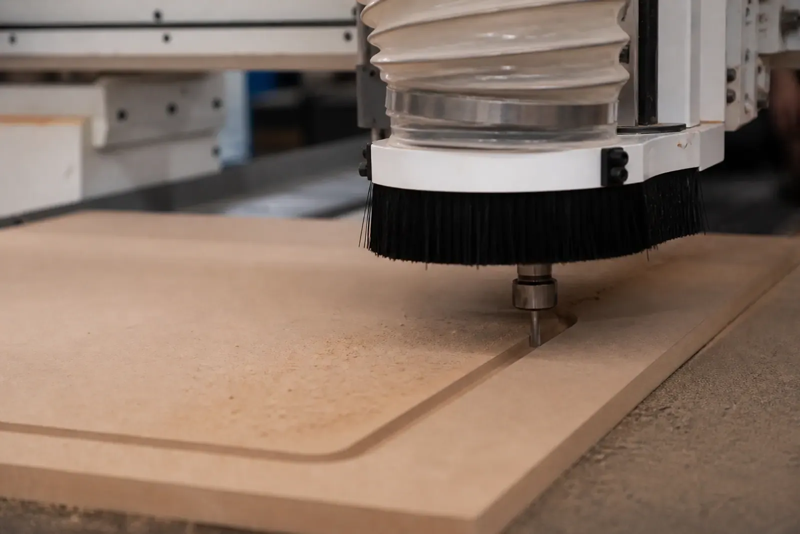 CNC router machining a controlled groove in an MDF panel