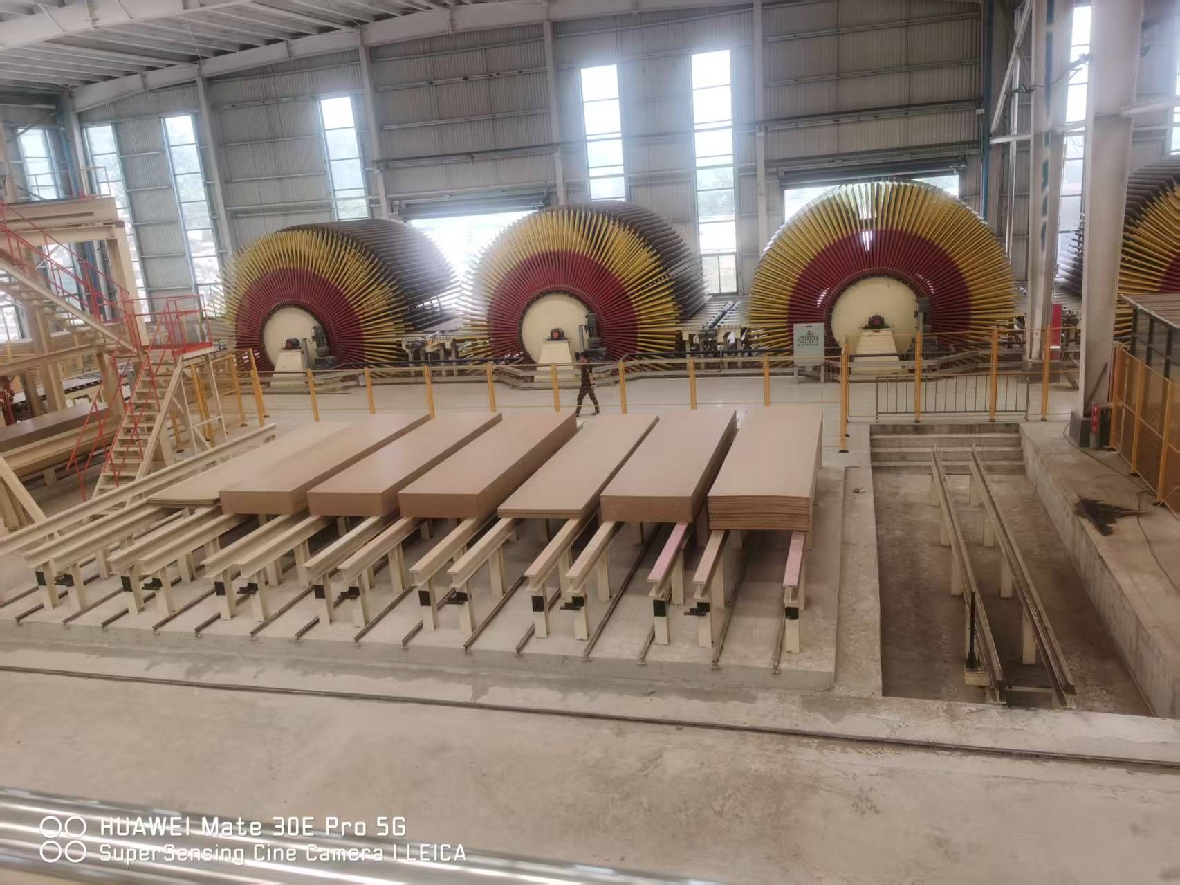 Board-handling equipment and stacked panels inside the CUZI MDF workshop